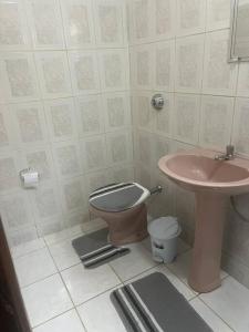 un bagno con un water rosa e un lavandino di Tradição e Conforto em Santa Efigênia a Belo Horizonte