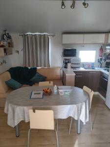 a living room with a table and a kitchen at L'orée du bois in La Boissière-de-Montaigu