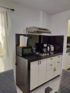 a kitchen with a counter top with a microwave at Casa Bugambilia Downstairs Unit in Balamban +7 photos