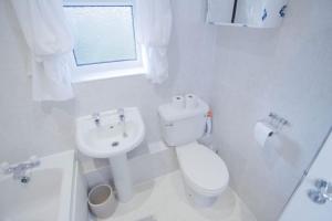a white bathroom with a toilet and a sink at 2 Bed House - BHX - NEC in Solihull +6 photos