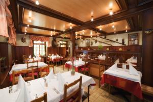 a restaurant with white tables and chairs in a room at Logis Hôtel-Restaurant Auberge Du Mehrbachel in Saint-Amarin