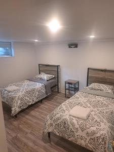 a room with two beds and a table at Confort belles chambres privées dans un duplex in Montreal