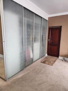 センチュリオンにあるBlue Valley Golf Estateのガラスの引き戸とドアが付いた空間