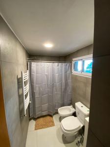 Un pequeño baño con inodoro y ducha. en Departamento 66 - cochera opcional -, en La Plata