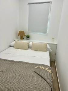 a bedroom with a bed with a lamp on it at Apartamento Turístico Centro Antequera B in Antequera