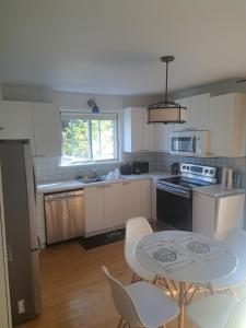 a kitchen with a table and a table and chairs at Confort belles chambres privées dans un duplex in Montreal