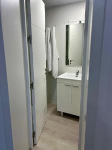 a white bathroom with a sink and a mirror at Apartamento Turístico Centro Antequera B in Antequera +5 photos