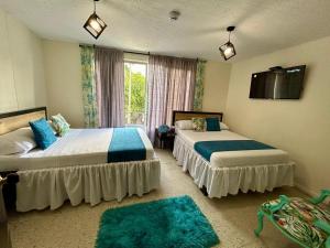 a bedroom with two beds and a window at Hotel Bisou in Cali