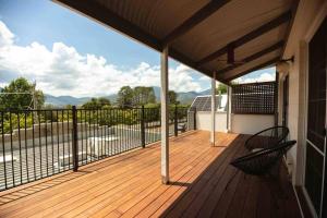 a porch with two chairs on a wooden deck at Central Two Bedroom Apartment With Mountain Views in Mount Beauty