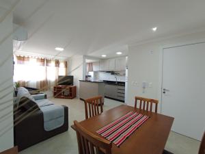 una cucina e un soggiorno con un tavolo e un divano di Apartamento Central Climatizado e Aconchegante a Torres