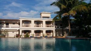 a building with a swimming pool in front of it at Hotel Riverside in Baga