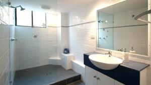 a bathroom with a sink and a glass shower at Esplanade View Unit 3 Wollombi in Caloundra