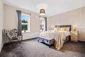 a bedroom with a bed and a chair and a window at 4BR Family Home in 89 Highgate with Jacuzzi, Games Room & Free Parking Near Birmingham in Walsall