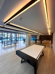 a ping pong table in a room with tables at Porto Alto Resort Muro Alto B02-215 - 224 in Ipojuca