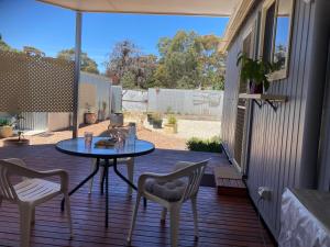 a patio with a table and chairs on a deck at The Little House in Golden Square