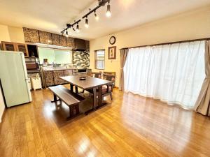 a living room with a table and a kitchen at JP Style Guest House 圭堂-Seidou- Free for rental bicycle and the washing machine and dry machine!!自転車レンタル無料!!無料ランドリー有!! in Fujiyoshida