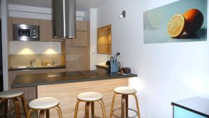 a kitchen with a counter with stools in it at La Grande Bouisse gites avec piscine dans le Luberon, Provence in Céreste
