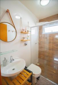une salle de bain avec un lavabo, des toilettes et une douche dans l'établissement Linda casa em Juquehy a 150 metros da praia!! Casa em condomínio!, à São Sebastião