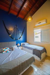 - une chambre avec 2 lits et un filet sur le mur dans l'établissement Linda casa em Juquehy a 150 metros da praia!! Casa em condomínio!, à São Sebastião