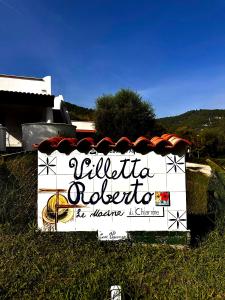 a sign in the grass with a sign for a restaurant at Villetta Roberto Le Macine di Charme - Pugnochiuso Resort in Vieste