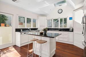 a kitchen with white cabinets and a black counter top at The Cove Church Point in Church Point