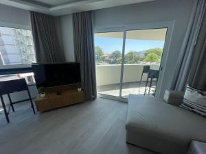 a living room with a couch and a flat screen tv at Luxurious T2 Varandas Apartment XIII in Funchal