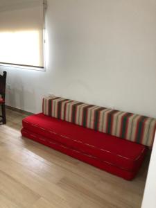 a red couch sitting on the floor in a room at Hermoso chalet en Parque Luro, Mar del Plata in Mar del Plata