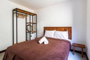 a bedroom with a large bed with two towels on it at Casa com Piscina 20 metros do mar - Milagres in Passo de Camarajibe +40 photos