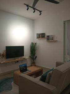a living room with a couch and a laptop on a table at The Shore Seaview A1817 in Kota Kinabalu