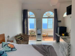 a bedroom with a bed and a view of the ocean at Vitorina Corte Guesthouse in Funchal