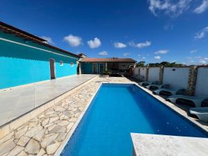 - une piscine avec des chaises à côté d'une maison dans l'établissement Casa na região dos lagos, à São Pedro da Aldeia