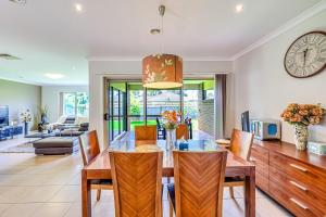 Un comedor y una sala de estar con mesa y sillas. en StayAU Spacious Stay Point Cook, en Point Cook