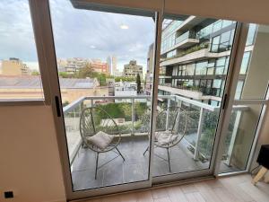 a balcony with two chairs and a view of a building at Arevalito Monoambiente in Buenos Aires