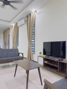 クアラ・トレンガヌにあるD'Yanaa Homestayのソファと薄型テレビのあるリビングルーム +4枚の写真