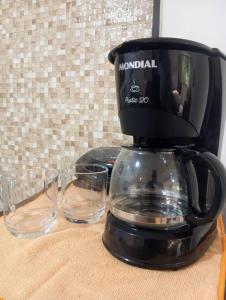 アングラ・ドス・レイスにあるVibração Positivaのコーヒーメーカー、テーブルにグラス2杯