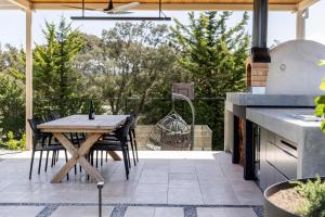 an outdoor kitchen with a wooden table and chairs at Serendib Luxury Sorrento Resort Living in Sorrento