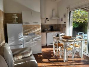 a kitchen with a table and a white refrigerator at Mas Nina Rosa in Mazan