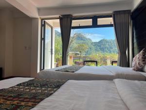 two beds in a room with a large window at Sapa Village Hotel in Sapa +53 photos