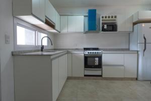 a white kitchen with a sink and a stove at Descubre Salta desde este Duplex acogedor in Salta +25 photos