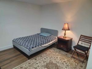 a bedroom with a bed and a chair and a lamp at Forest city House -Rooms in a family style in London