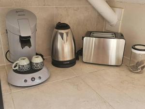 a blender and a coffee maker on a counter at studio La Cocoteraie, vue mer in Courcelles Sucrerie