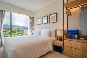 a hotel room with a bed and a tv at Laguna Lakeside Residences by Banyan Living in Bang Tao Beach
