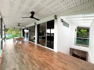 a living room with a ceiling fan and a wooden floor at 4 bed rooms sea view villa with pool in Chaloklum