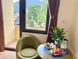 a room with a table and a chair and a window at Sun Hà Giang Hotel-tours-motorbike rental in Ha Giang