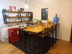 a kitchen with a wooden table and a red refrigerator at Acogedora y amplia Casa in Puchuncaví