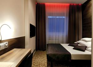 une chambre d'hôtel avec un lit et une fenêtre dans l'établissement Nu Hotel, à Łódź