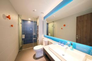 a bathroom with a sink and a toilet and a mirror at Holiday Inn Express Quanzhou City Center by IHG in Quanzhou +41 photos