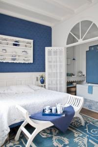 um quarto com uma cama branca e uma parede azul em Maison d'Hôtes La Guérandière em Guérande