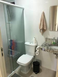 a bathroom with a shower and a toilet and a sink at Apartamento aconchegante na Praia in Ubatuba