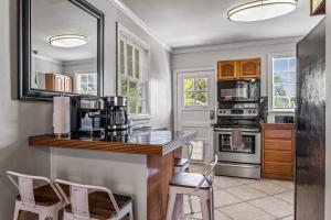 a kitchen with a counter and two stools in it at East Hill Manor with 2 Kitchens Near Beach & Downtwn in Pensacola